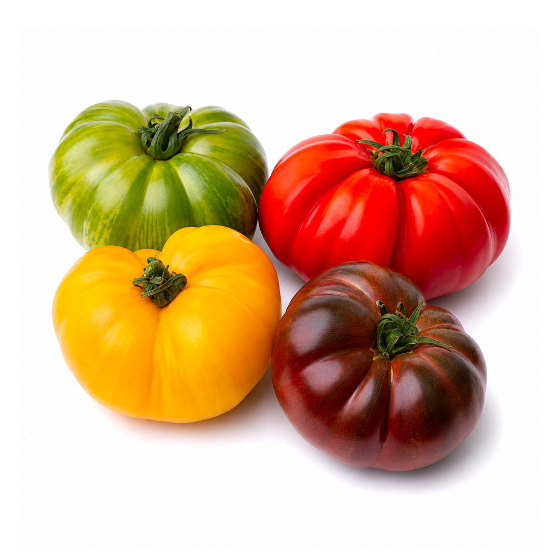 A pile of mixed Heirloom tomatoes in red, yellow, orange, green and dark purple with ridged round and oblong shapes on a white background.